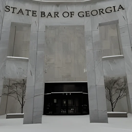 The entrance of the State Bar of Georgia building, featuring tall marble columns, large windows, and the organization’s name displayed above the door.