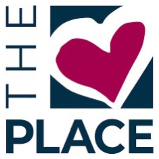 Logo with the words “THE PLACE” and a stylized red heart shape inside a blue square, with “THE” written vertically on the left.