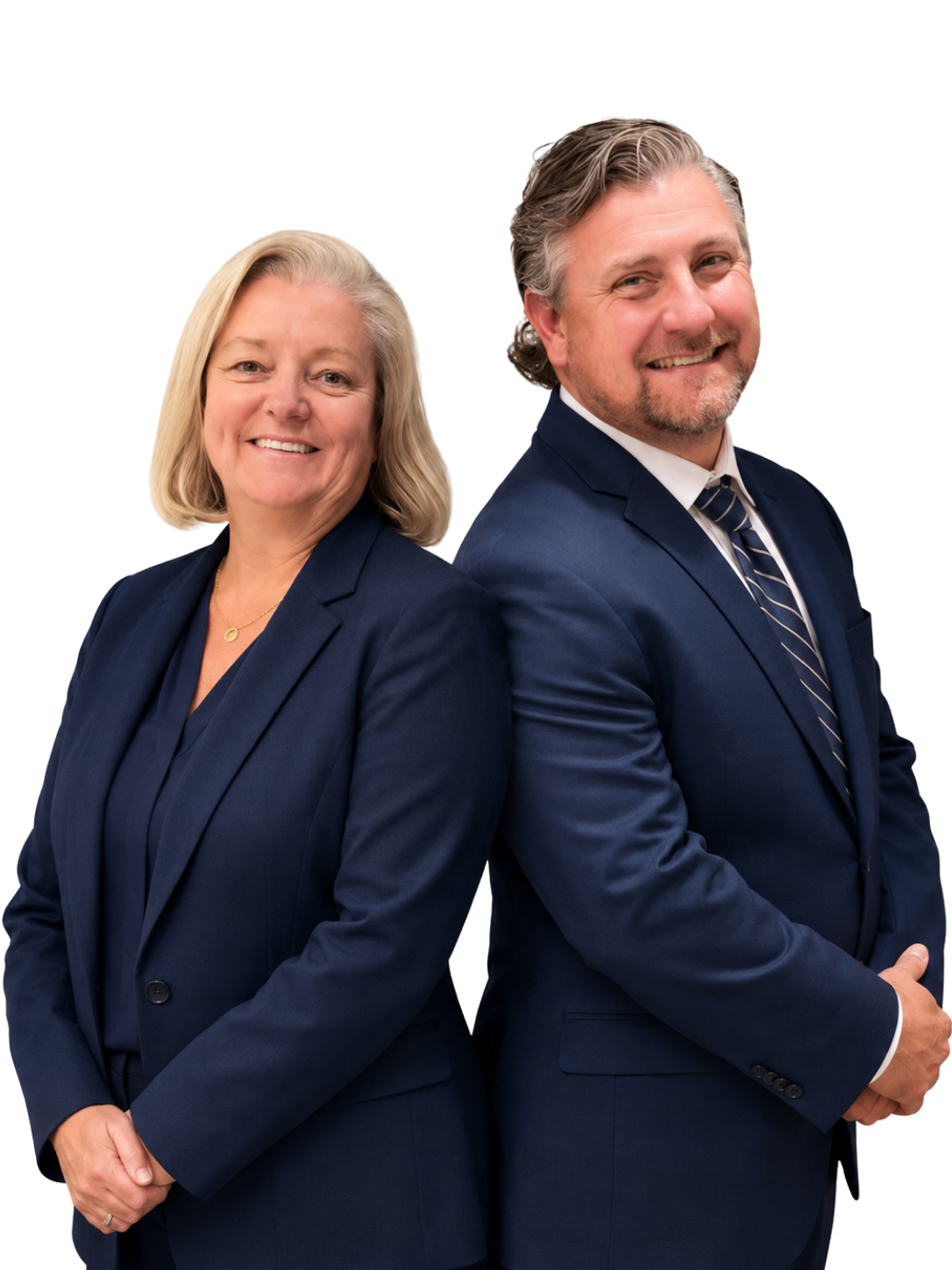 Two adults, a woman and a man, stand back to back in navy suits, smiling at the camera against a plain white background.