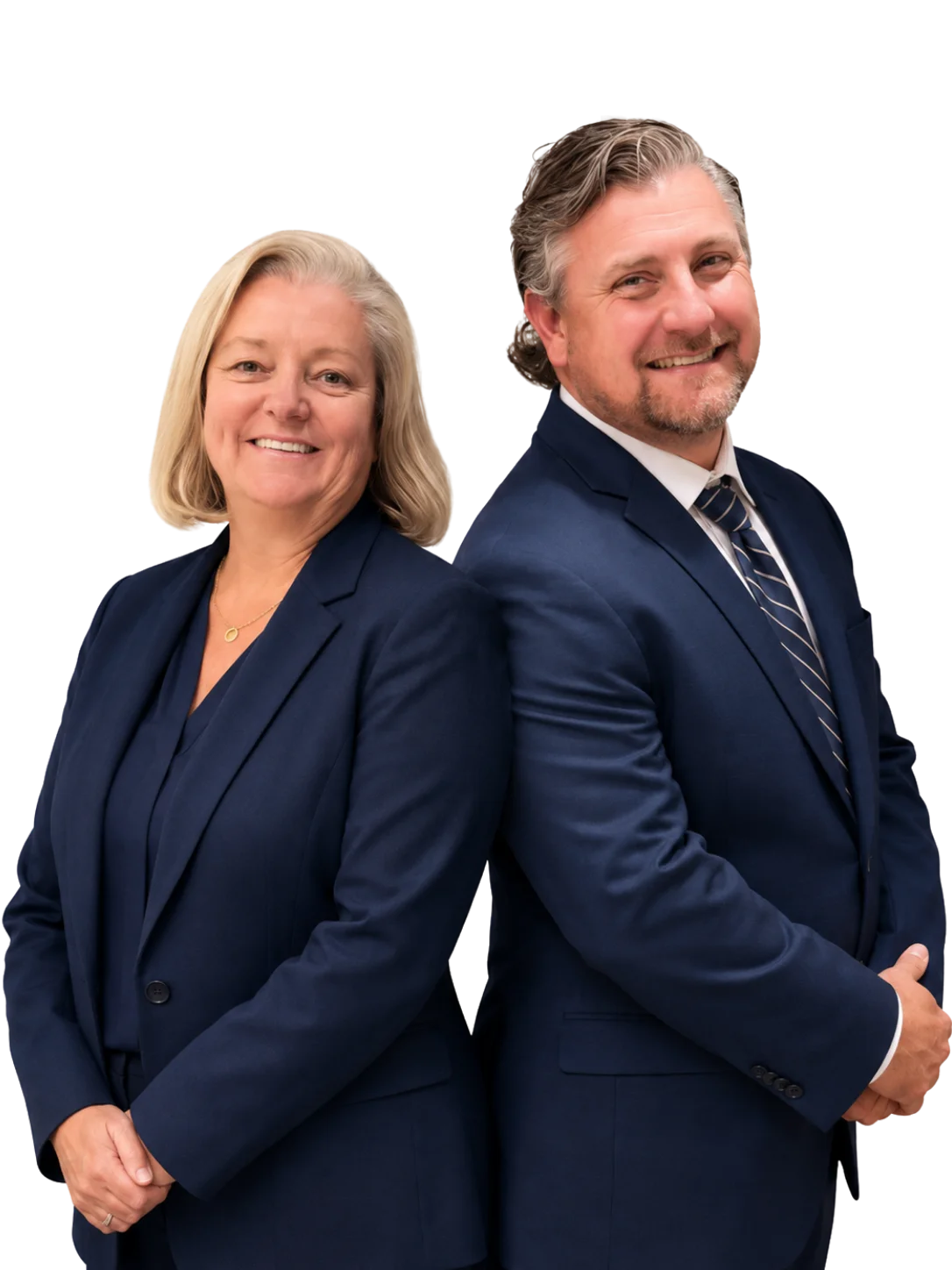 Two adults, a woman and a man, stand back to back in navy suits, smiling at the camera against a plain white background.